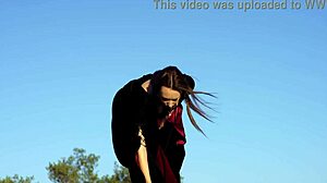 Brunette with big tits stands on rock playing outdoors