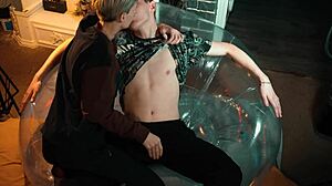 Two sweet guys share an inflatable chair, relaxing together in a casual setting