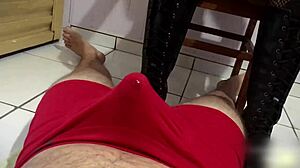 Tall couple in long leather boots, she gives footjob until he cums in pants.