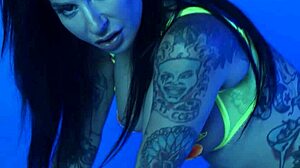 petite busty milf joanna angel undresses from her colorful neon lingerie, revealing big tits and naked body in a solo striptease