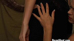 Sensual submissive lesbian slave in bondage kissing and licking mistress's pussy while bound and punished in femdom domination.