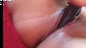 Sensual latina teen masturbates with dildo on bed showing wet pussy lips close-up